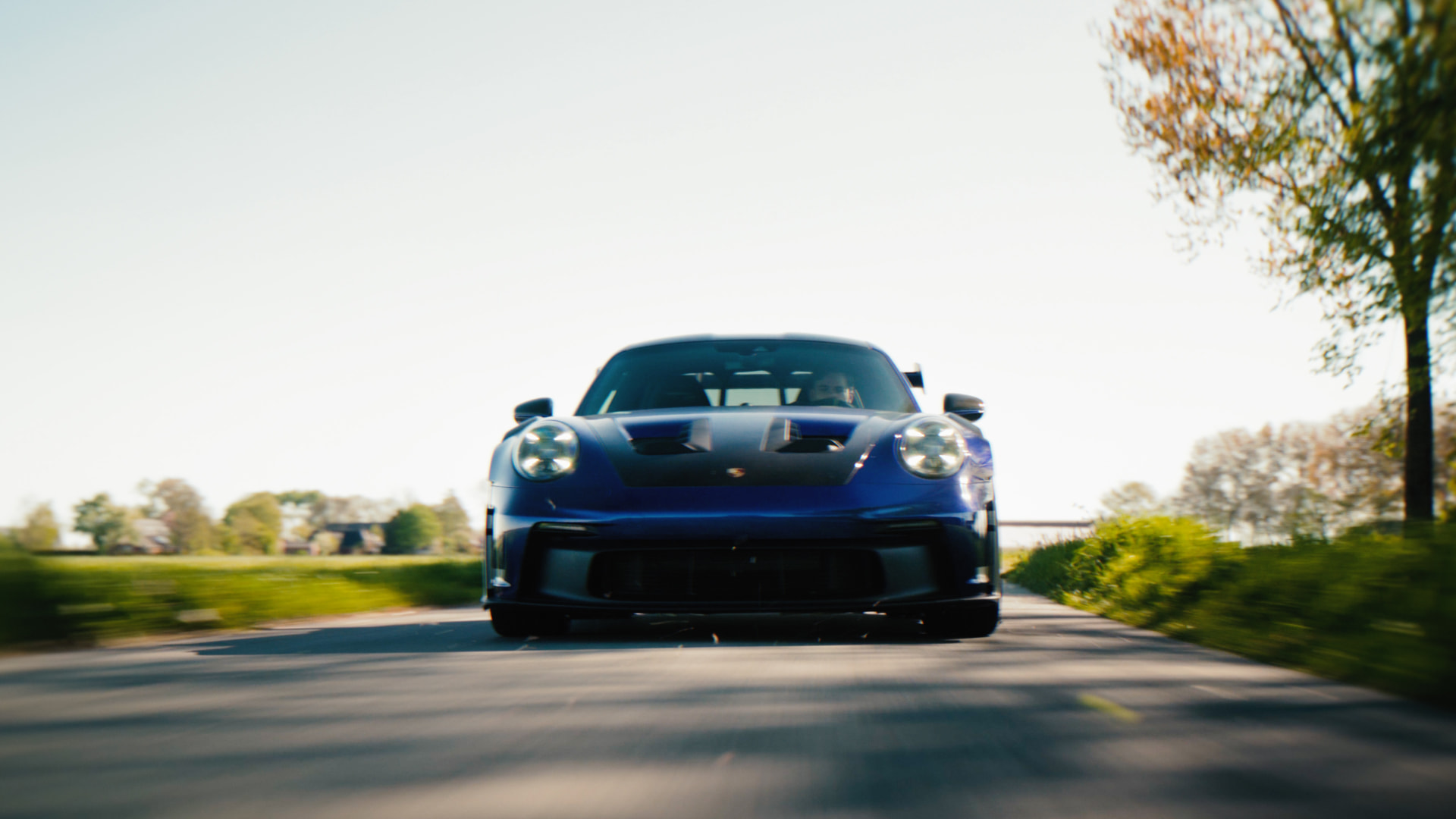 Blauwe Porsche op een landweg