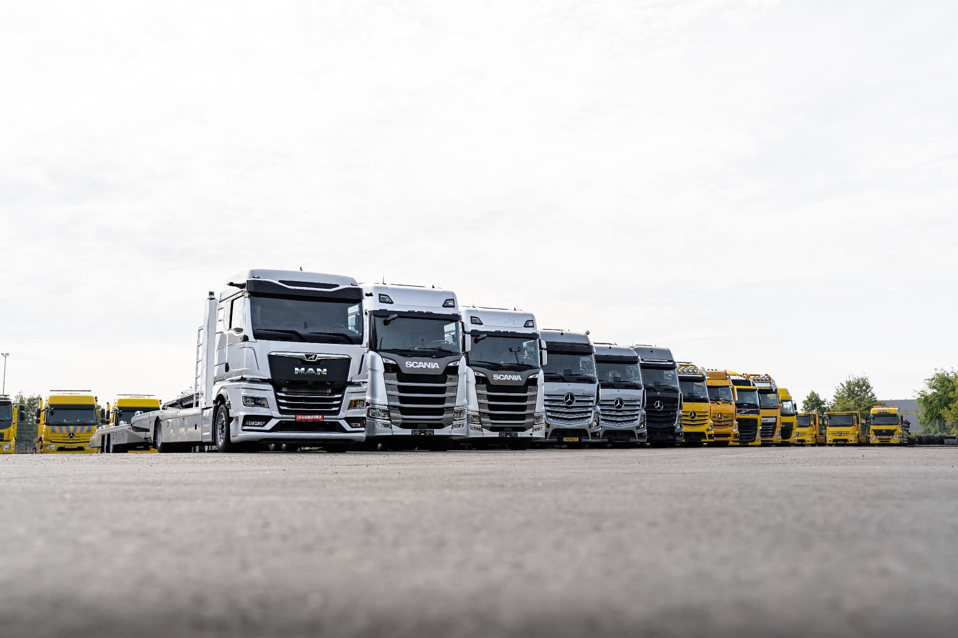 Rij opleggers en trucks opgesteld op het buitenterrein