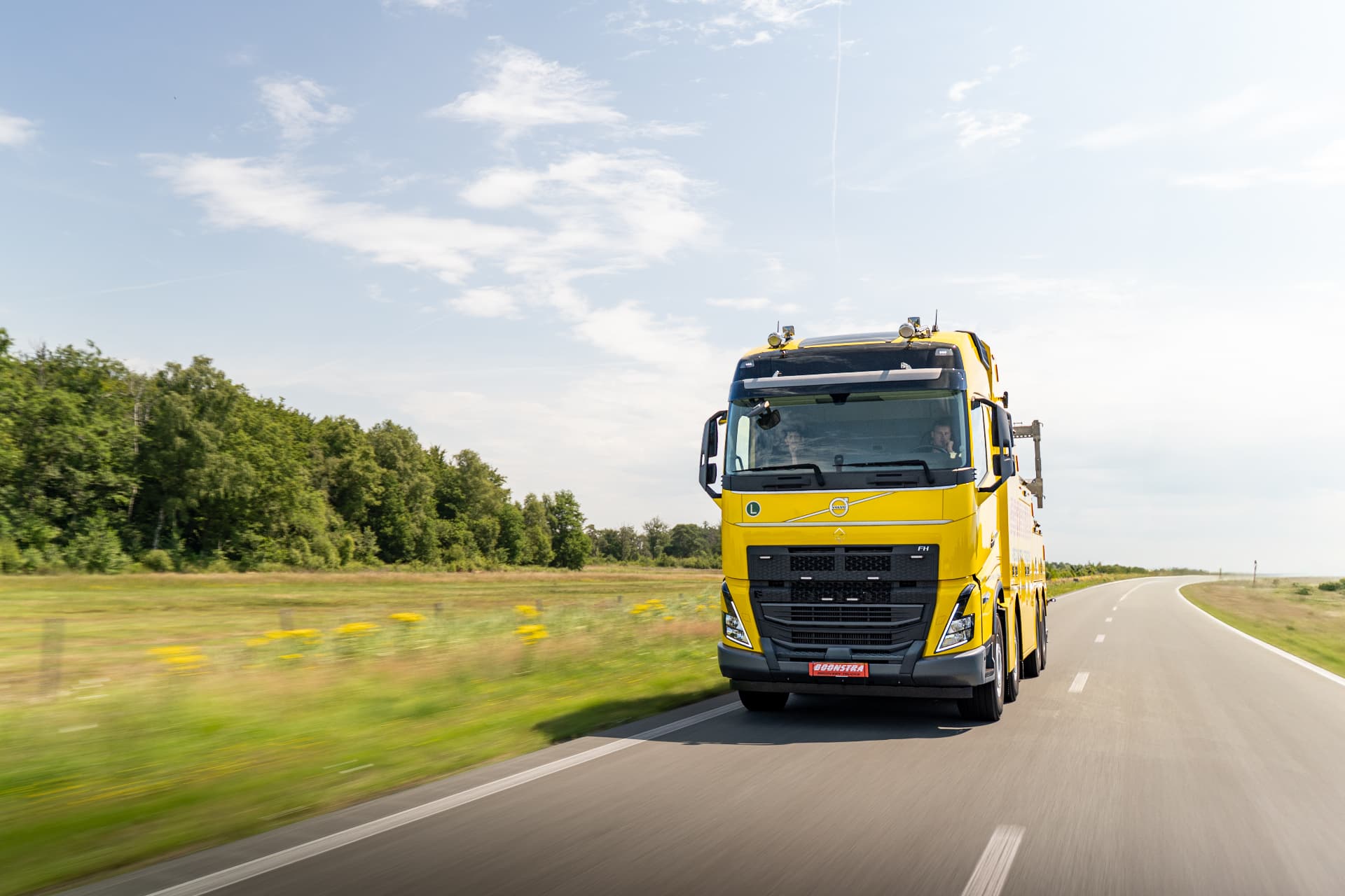 Gele Volvo FH-berger rijdend op een provinciale weg